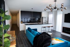 Seaford的住宿－Luxury Cozy 2Bdr Apt WiFi ☆ Netflix ☆Gas Log Fire，一间带蓝色沙发的客厅和一间厨房