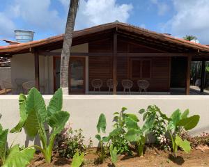 uma casa com cadeiras e plantas em frente em Pousada Alma Noronha em Fernando de Noronha