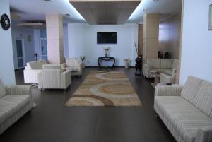 una sala de espera con sofás blancos y una alfombra en Hotel Maria, en Constanţa