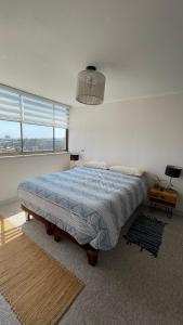 Schlafzimmer mit einem großen Bett mit blauer Decke in der Unterkunft Vista Valparaíso Barrio Inglés in Valparaíso