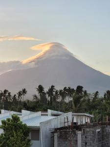 uma montanha à distância com palmeiras e um edifício em ANDY'S PLACE em Legazpi