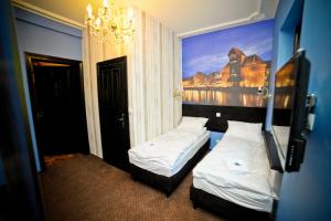 une chambre d'hôtel avec 2 lits et un tableau mural dans l'établissement World Hostel - Old Town, à Gdańsk