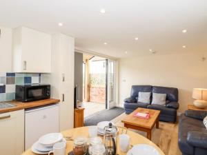 a kitchen and living room with a couch and a table at The Cart Lodge in Halstead