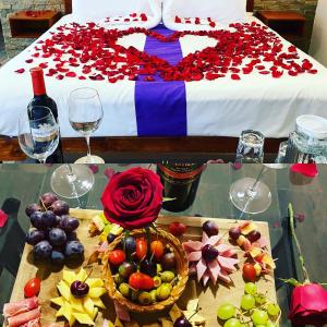 a table with a bed with a bowl of fruit and wine glasses at Hotel & Suites Cerro Roj0 in Tlatlauquitepec