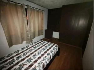 um quarto com uma cama e uma janela com cortinas em La Muralla em Cuenca