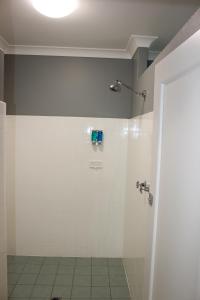 ein Bad mit einer Dusche und einer weißen Wand in der Unterkunft Colliery Inn Wallsend in Newcastle