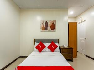 a bedroom with a bed with red pillows at OYO 805 La Belladoza in Manila