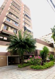 a building with a palm tree in front of it at Aconchego no Rio in Rio de Janeiro