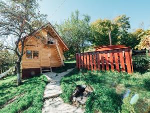 ein Blockhaus mit einem Zaun neben einem Hof in der Unterkunft Relaxare in Sohodol, Alba in Sohodol