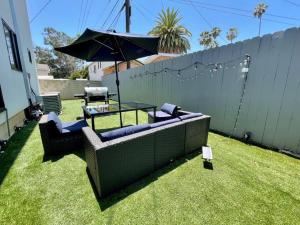 un patio con 2 sofás y una mesa con sombrilla en Newly Built Townhouse - Prime Hollywood Location, en Los Ángeles