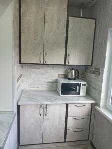 a kitchen with a microwave on top of a counter at Квартира in Shymkent