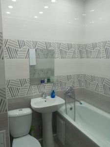 y baño con lavabo, aseo y bañera. en Квартира en Shymkent