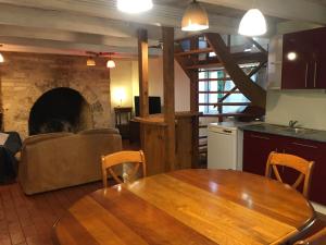 Il comprend une cuisine et une salle à manger avec une table et une cheminée. dans l'établissement Maison chaleureuse, à Montignac