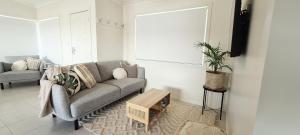 Bongaree的住宿－Weeroona on Nulu，客厅配有沙发和桌子