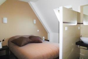 a bedroom with a bed and a sink in a room at Semi-detached house, Ploumilliau in Ploumilliau