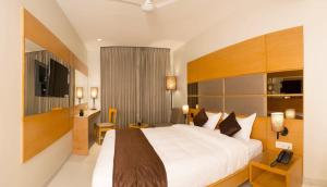 a hotel room with a large bed and a desk at Sri Aadhish Grand Hotel in Arantāngi