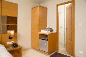 a small room with a bed and a small cabinet at Sri Aadhish Grand Hotel in Arantāngi +32 photos