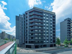 ein hohes Gebäude mitten in einer Stadt in der Unterkunft CHISUN STANDARD Kyoto Horikawa Gojo in Kyoto