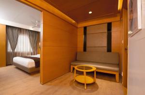 a bedroom with a bed and a stool in a room at Sri Aadhish Grand Hotel in Arantāngi