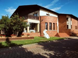 a brick house with a statue in front of it at C&C Karo Resort in Bacău