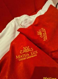un mucchio di asciugamani rossi seduti sopra un letto di Matija LUX Konaci a Zlatibor