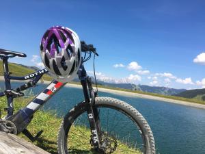 a bicycle with a helmet on it next to a river at Am Zwölferkogel Appartements in Saalbach-Hinterglemm