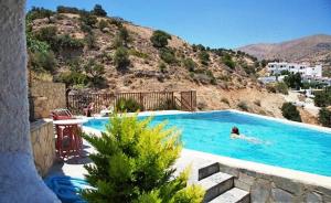 eine Person, die in einem Pool mit einem Berg schwimmt in der Unterkunft Sunlight Hotel in Agia Galini