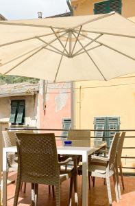 ヴェルナッツァにあるLa Polena Camere Vernazza - Carattino Apartmentのパティオ(パラソル付きのテーブルと椅子付)