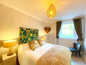 a bedroom with a bed and a lamp and a chair at Meadfoot Bay Apartment at Hesketh Crescent in Torquay