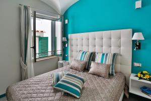 a bedroom with a large bed with a blue wall at Apartments Amalfi Design in Amalfi