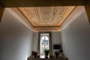 Cette chambre dispose d'un plafond à caissons et d'une fenêtre. dans l'établissement Domus 21 Luxury Suites, à Rome