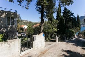 a fence in front of a house with a tree at Apartments Tramonto in Zaton