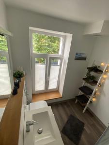 a bathroom with a white sink and a window at FeWo Jade in Wilhelmshaven