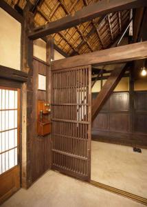un fienile con una grande porta in legno in una stanza di もしもしの家 a Koshu