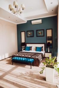 1 dormitorio con cama y pared azul en Chernivtsi Arbat en Chernivtsi