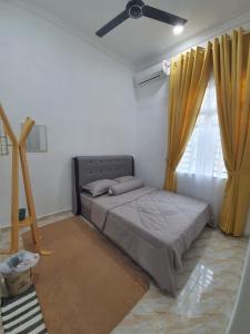 - une chambre avec un lit et un ventilateur de plafond dans l'établissement Casa De Rose KUBANG KERIAN, à Kota Bharu