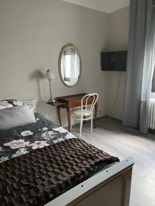 1 dormitorio con cama, mesa y espejo en Parel aan de Moezel, en Bruttig-Fankel