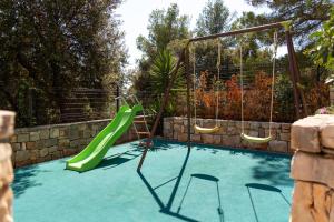 ミルナにあるHouse Ankaの緑の滑り台とブランコ付きのスイミングプール