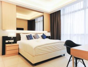 a bedroom with a large white bed and a desk and a desk at Grand Ion Delemen Hotel in Genting Highlands