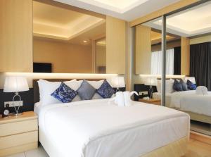 a bedroom with a large white bed with blue pillows at Grand Ion Delemen Hotel in Genting Highlands