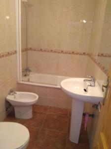 łazienka z umywalką, toaletą i wanną w obiekcie Casa Rural el Maestro I w mieście Navalosa