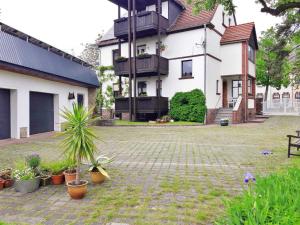 ein großes weißes Haus mit Topfpflanzen in einem Hof in der Unterkunft Ferienwohnung Ahrens in Hoyerswerda