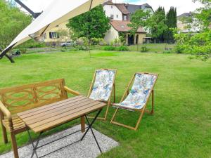two chairs and a wooden bench in a yard at Ferienwohnung Ahrens in Hoyerswerda
