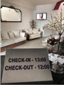 a living room with a sign that reads check in check out at Casa Regala EAR in Craiova +31 photos