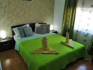 a bedroom with a green bed with two hats on it at Casa Regala EAR in Craiova