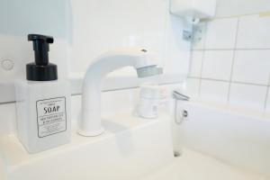 福冈Fukuoka Condominium的一间带盥洗盆和柜台上的肥皂分配器的浴室 更多37张照片