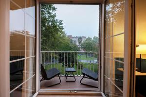 d'un balcon avec deux chaises et une vue sur un parc. dans l'établissement Apartamento Tíbula Sur Parking, à Mérida