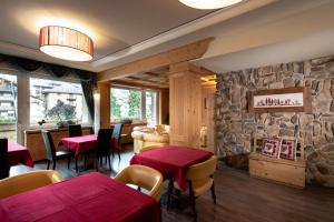 a restaurant with two tables and a stone wall at Sport Hotel S. Vigilio in Moena