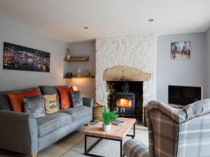 a living room with a couch and a fireplace at Hillside Cottage in Tetbury