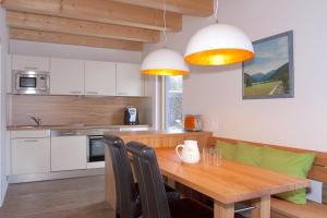 una cucina con tavolo in legno e una sala da pranzo di Ferienhaus Alpenflair bei Schliersee a Schliersee